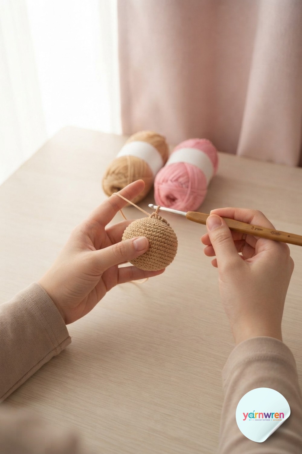 Hands working a magic ring into the first rounds of a crochet puppy amigurumi head sphere